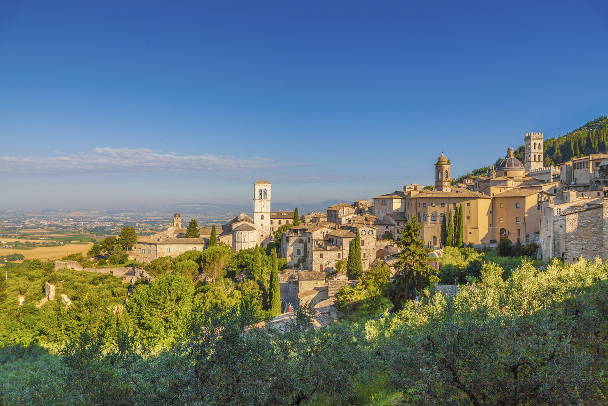 Panoramic view of the historic town of Assisi in beautiful golden morning light at sunrise in summer, Umbria, Italy